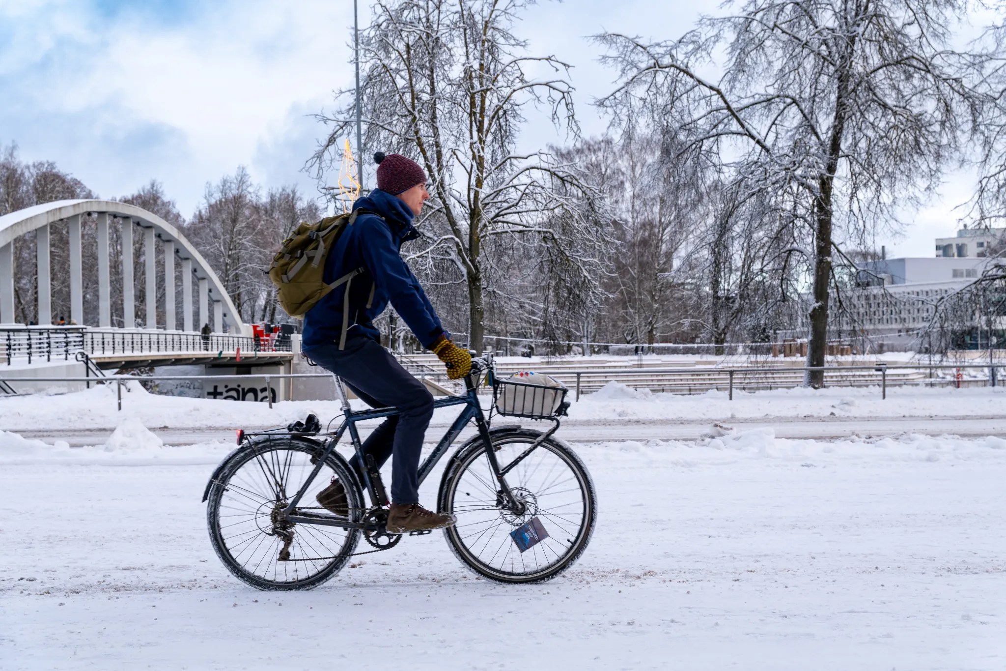Jalgrattur sõidab lumisel tänaval Tartu kesklinnas