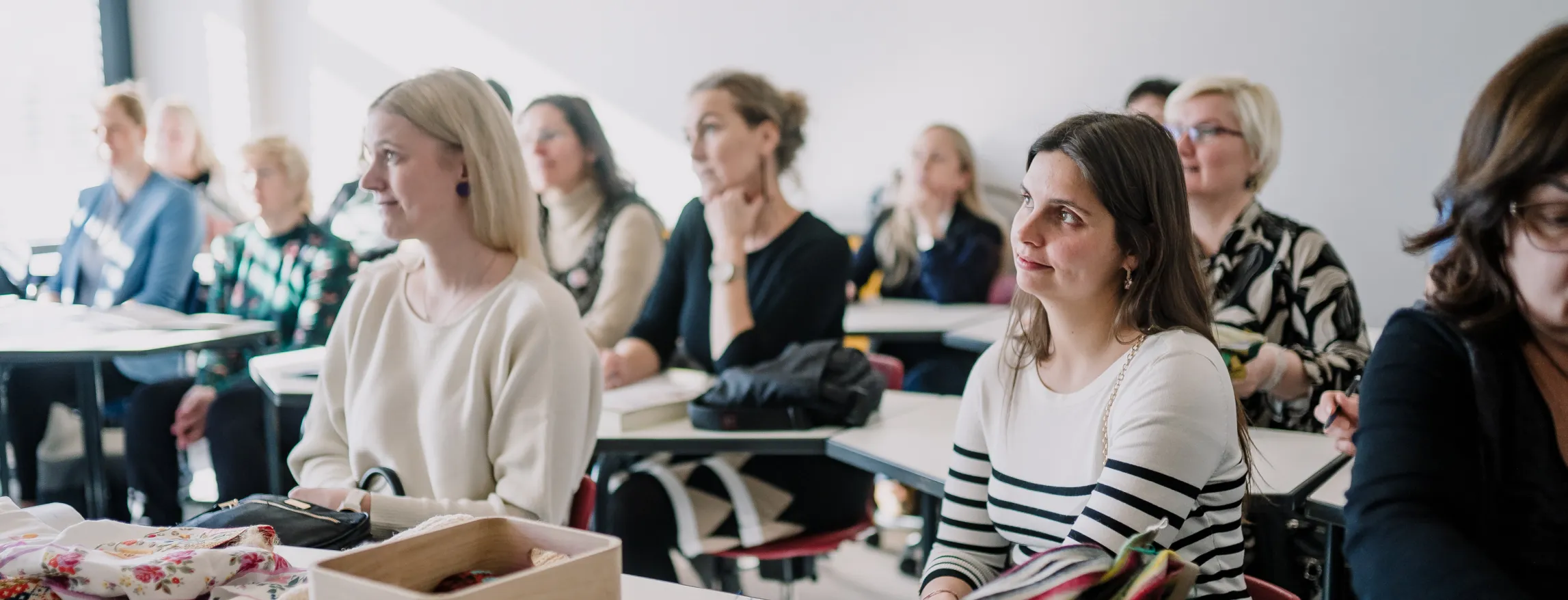 Õpetajad istumas klassiruumis kuulamas ettekannet