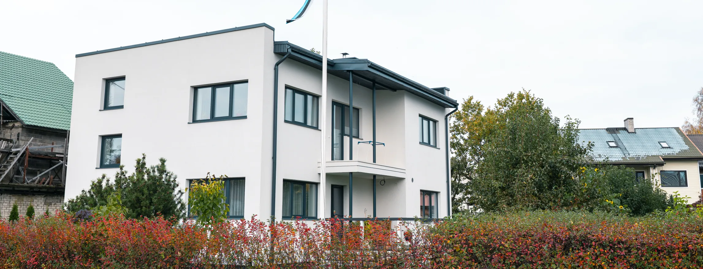 Valge eramaja Tartus koos sinimustvalge vimpliga.